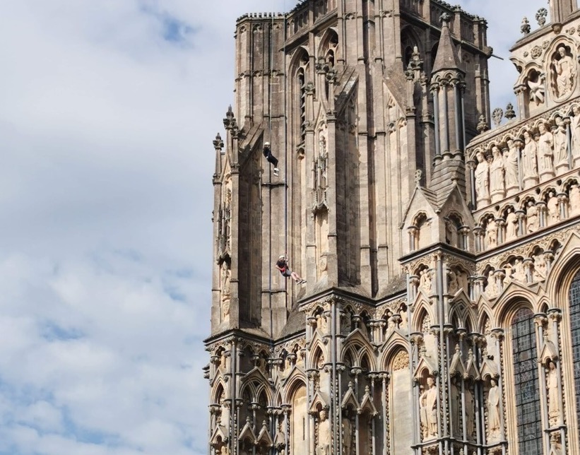 A photo of Rosie Carver descending the Well Cathedral in her Abseiling event to raise money for the charity Citizens Advice Mendip.