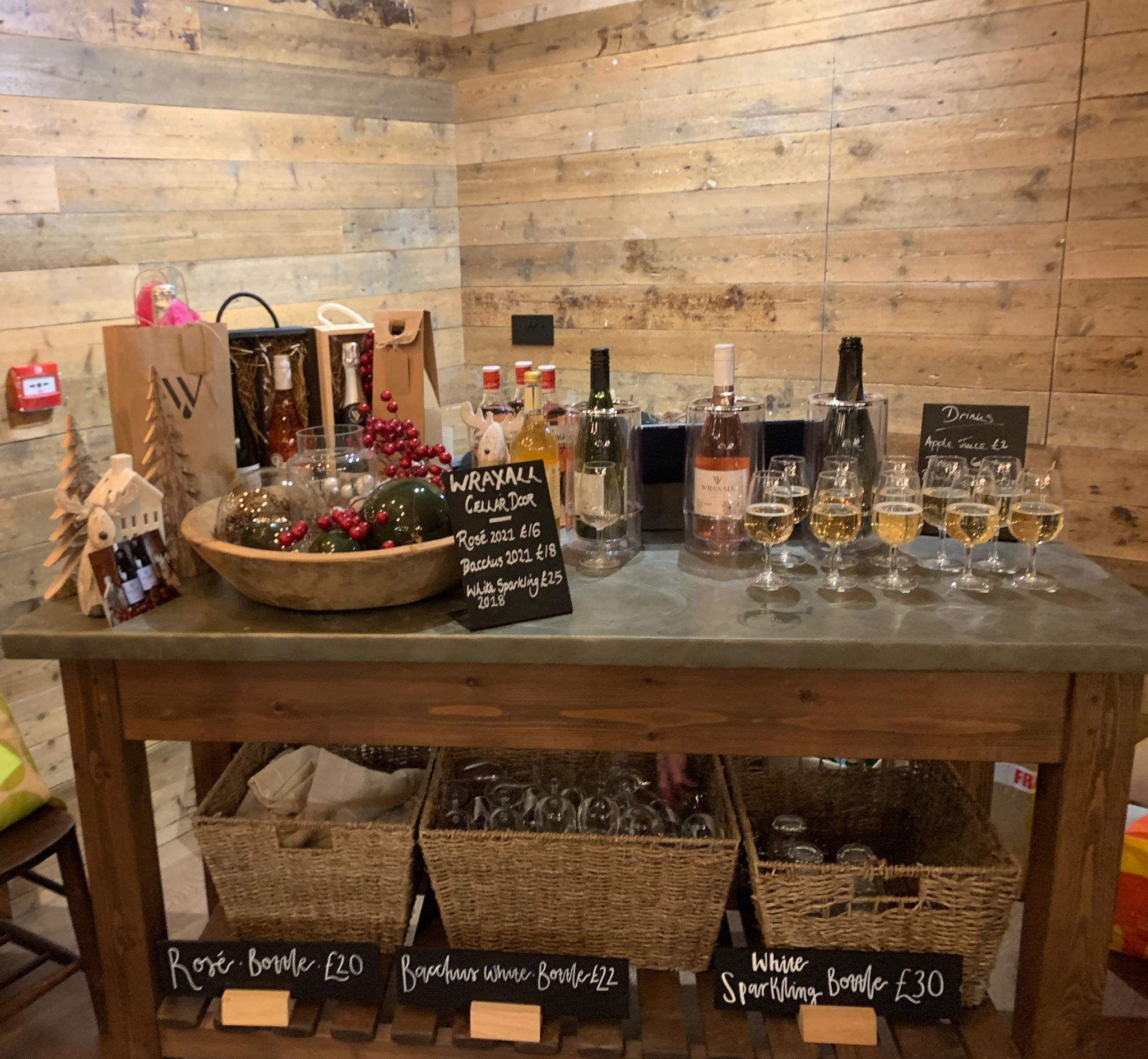 Display table with glasses of wine, gift bags, and empty glasses for the event.